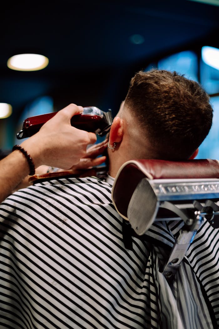 journey A barber skillfully trims a man's hair at a Geneva barber shop, showcasing precision and style.