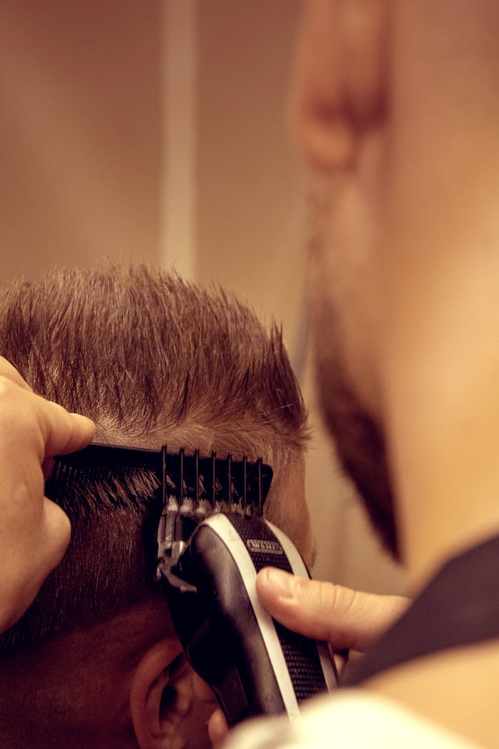 who-we-are Close-up image of a barber using an electric trimmer for a modern male haircut.